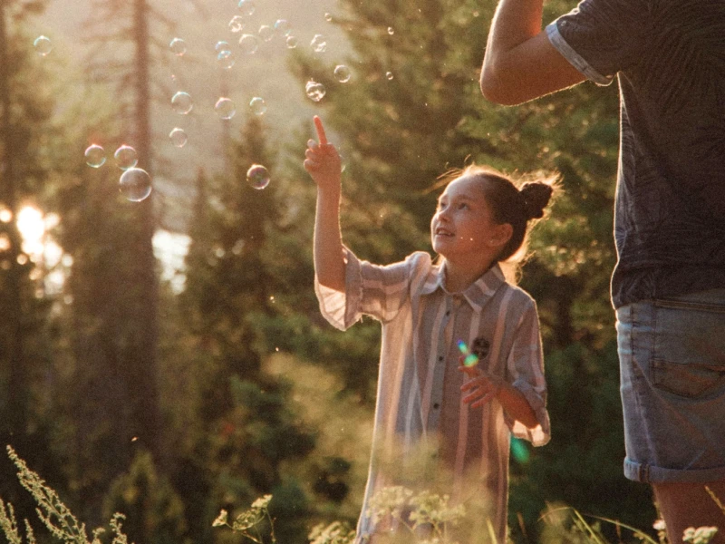 Kind spielt mit Seifenblasen