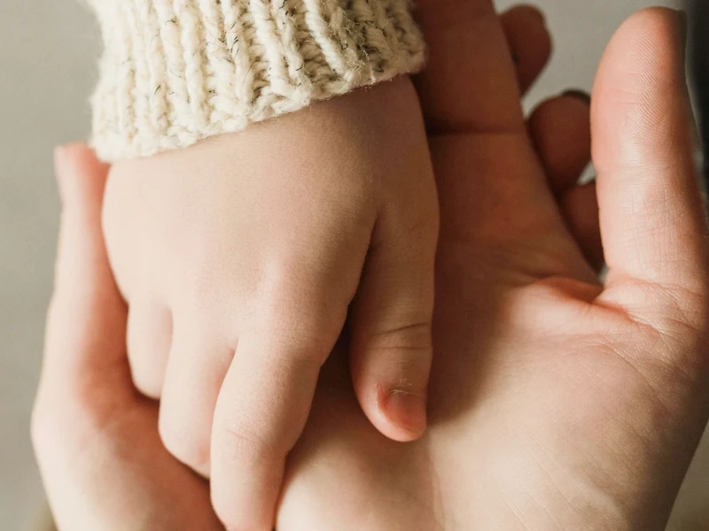 Hand eines Kindes liegt in Erwachsenenhand